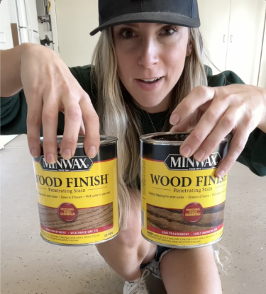 Person showing two cans of stains